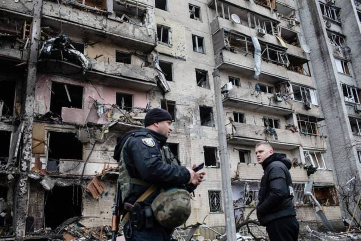 Residents and police inspect a fire damaged building following a blast at around 4 a.m. during Russian artillery strikes in Kyiv, Ukraine, on Friday. (Erin Trieb/Bloomberg News)