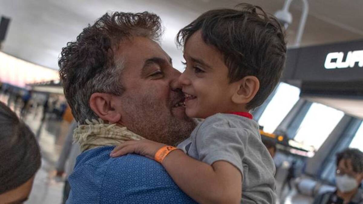 Mohammad Sadeed holds up his young son after being united after his family arrived back home from Afghanistan at Dulles International Airport. (Michael Blackshire/The Washington Post)
