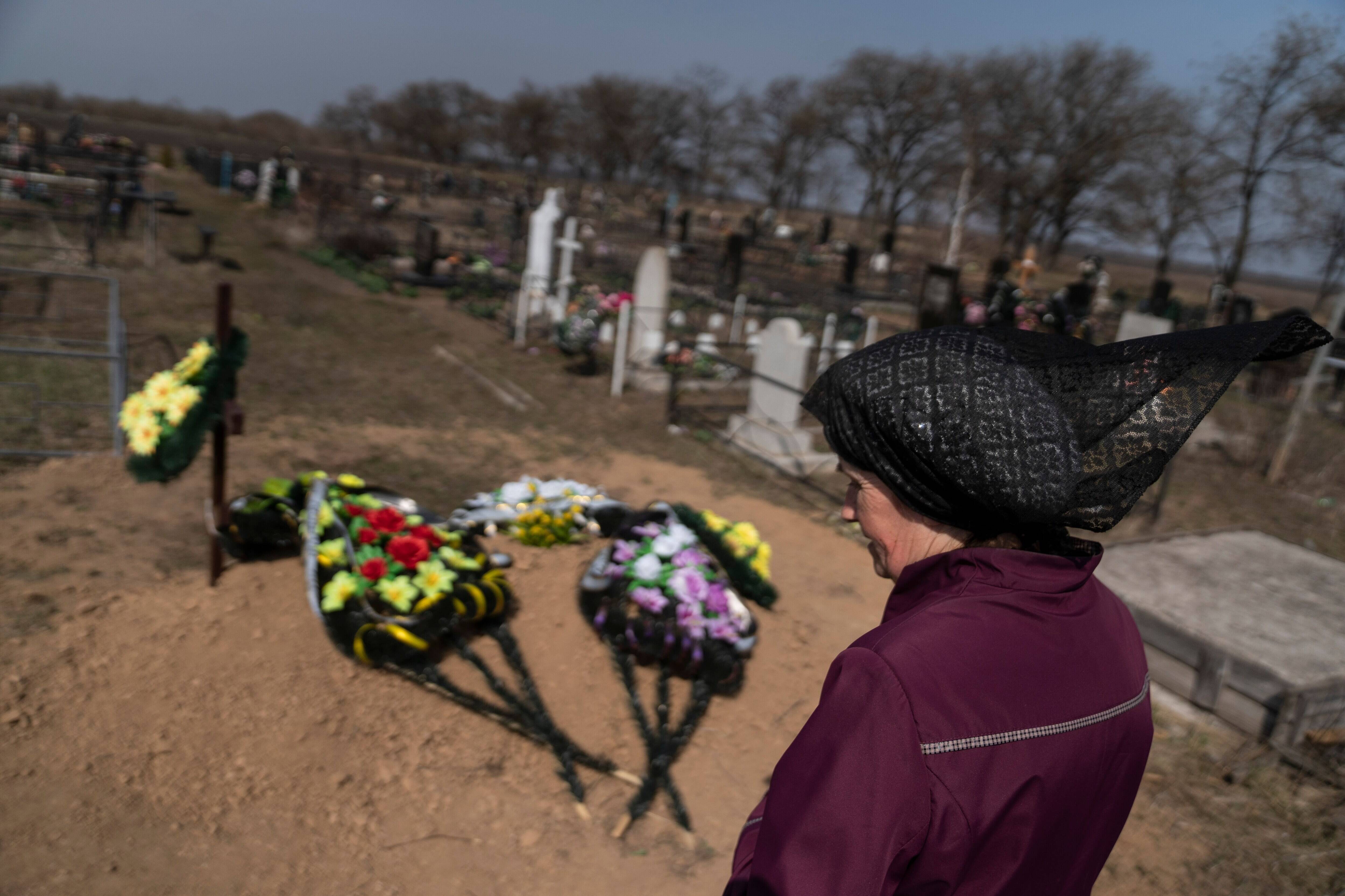 Tatiana Bozhiko stands next to the grave of her husband Serhi on March 30 in Lotskyne, Ukraine. (Michael Robinson Chavez/The Washington Post)