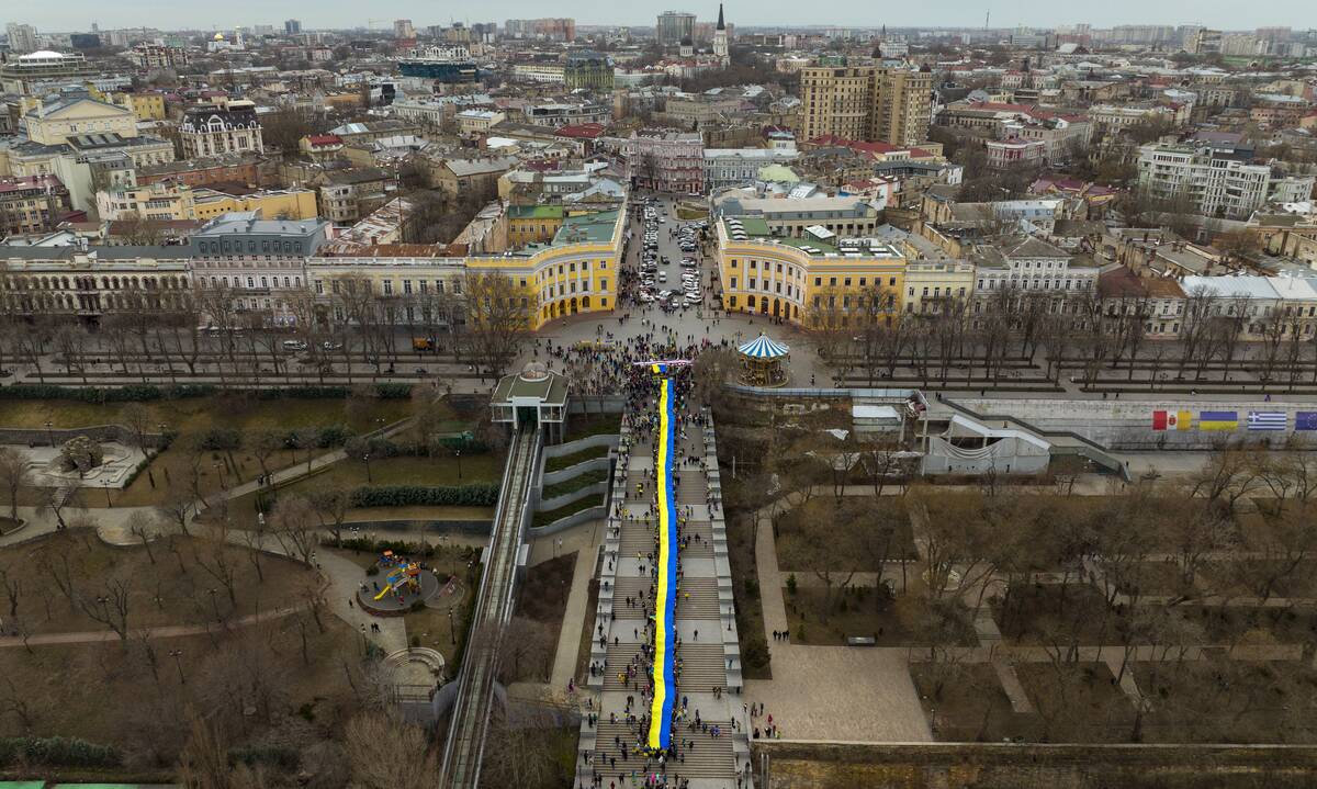 Demonstrators holding a huge Ukrainian flag march along the street in Odessa, Ukraine, on Sunday, Feb. 20. (Emilio Morenatti/Ap Photo)
