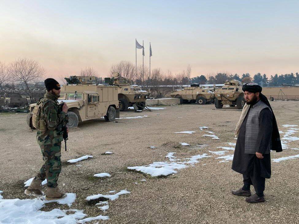 Ehsanullah Toufan, right, an Uzbek commander of a Taliban base in Maimana and a close friend of Makhdoom Alam's, inspects a line of American Humvees the Taliban had seized from former Afghan government forces, in Maimana, Afghanistan. (Sudarsan Raghavan/The Washington Post)