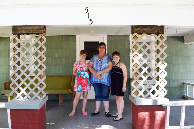 Elizabeth, Suzan and Jaiden Emonns stand on their porch in Iola, Kansas. (Ana Swanson/The Washington Post)</p>  