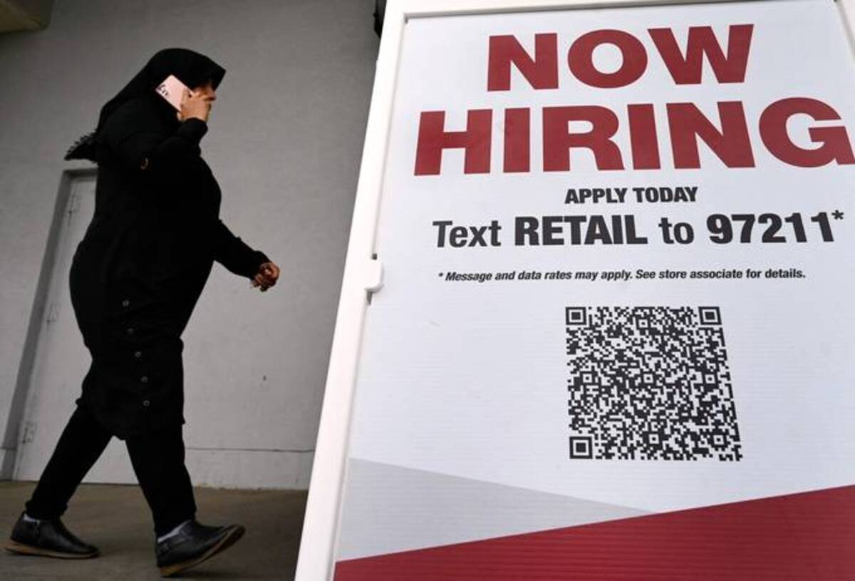 A woman wearing a face mask walks past a 