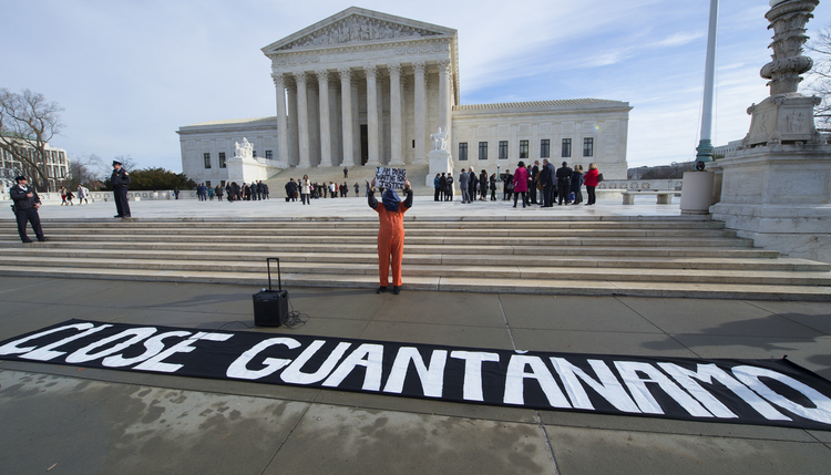 A protester holds up a sign during a rally at the Supreme Court yesterday calling for the closing of the Guantanamo Bay prison, to mark the 15th anniversary of the first Afghan prisoners arriving at the detention center. (AP Photo/Molly Riley)</p>  