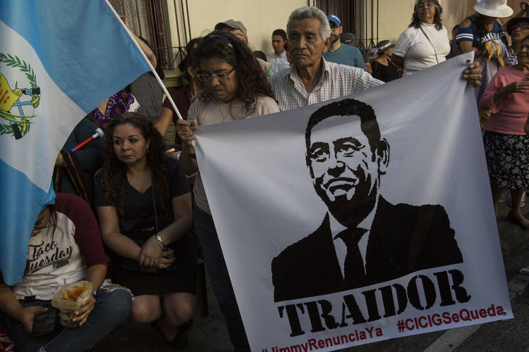 Demonstrators demand the resignation of Guatemalan President Jimmy Morales, featured in a poster Saturday that reads in Spanish "traitor,” after the government signed an agreement with the Trump administration to require migrants passing through the Central American country to seek asylum there, rather than pushing on toward the United States. (Oliver de Ros/AP)  