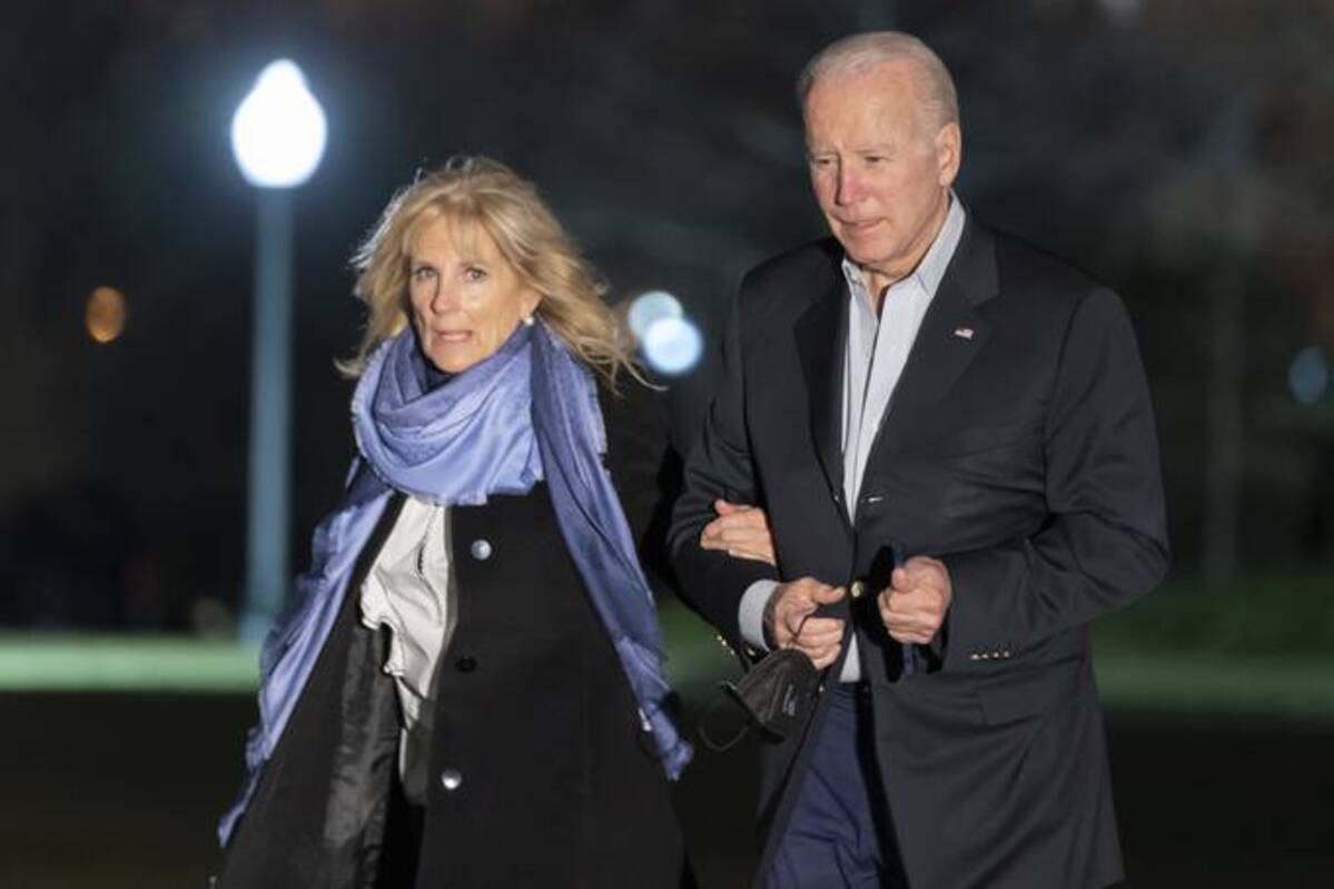 President Biden and first lady Jill Biden walk from Marine One upon arrival on the South Lawn of the White House on Sunday. (Alex Brandon/AP)