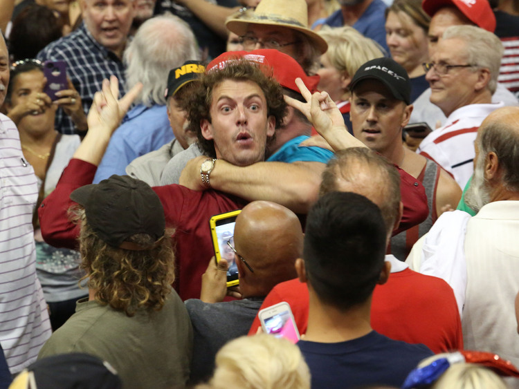 A&nbsp;Trump protester is held back by&nbsp;his supporters during a rally&nbsp;in Daytona Beach.(Red Huber/AP)</p>  