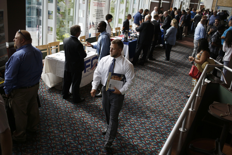 Job seekers speak with recruiters at a veterans job fair in Cleveland last week.&nbsp;(Luke Sharrett/Bloomberg)</p>  