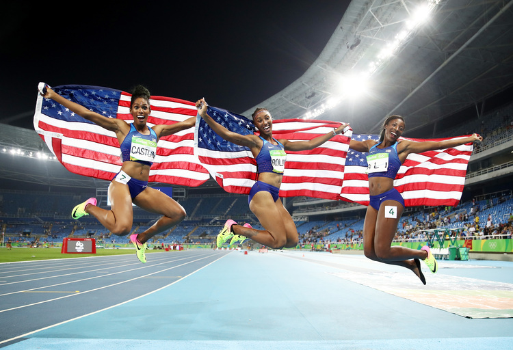 Kristi Castlin, Brianna Rollins, and&nbsp;Nia Ali celebrate with American flags after their win. (Cameron Spencer/Getty)</p>  