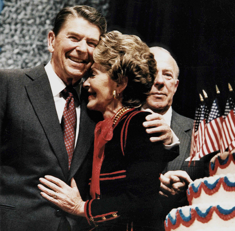 Ronald Reagan embraces Nancy at his 75th birthday party in 1986. That's&nbsp;Shultz on the right. (Mike Sargent/AFP)</p>  