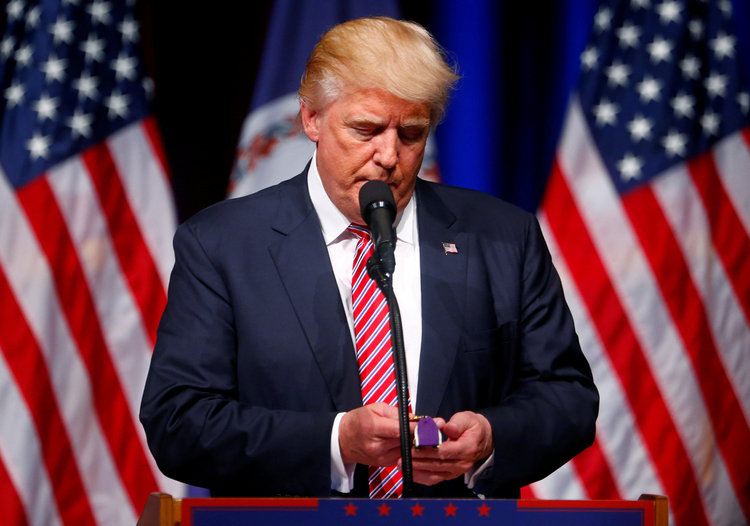 Trump holds a Purple Heart given to him during a campaign event in Ashburn, Virginia. (Reuters/Eric Thayer)</p>  