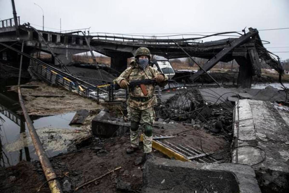 An armed Ukrainian commander by a destroyed bridge in the outskirts of Kyiv on Thursday. Ukrainian forces say the Russians destroyed the bridge. (Photo for The Washington Post by Heidi Levine).