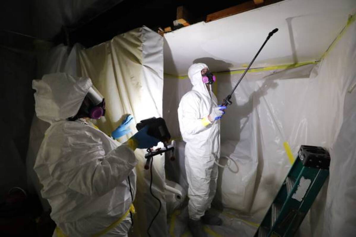 &nbsp;An asbestos removal crew works in Howell, Mich., in 2017. (Paul Sancya/AP)