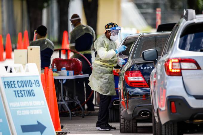 A health-care worker administers a swab test at a coronavirus testing site at Tropical Park in Miami on Aug. 6.