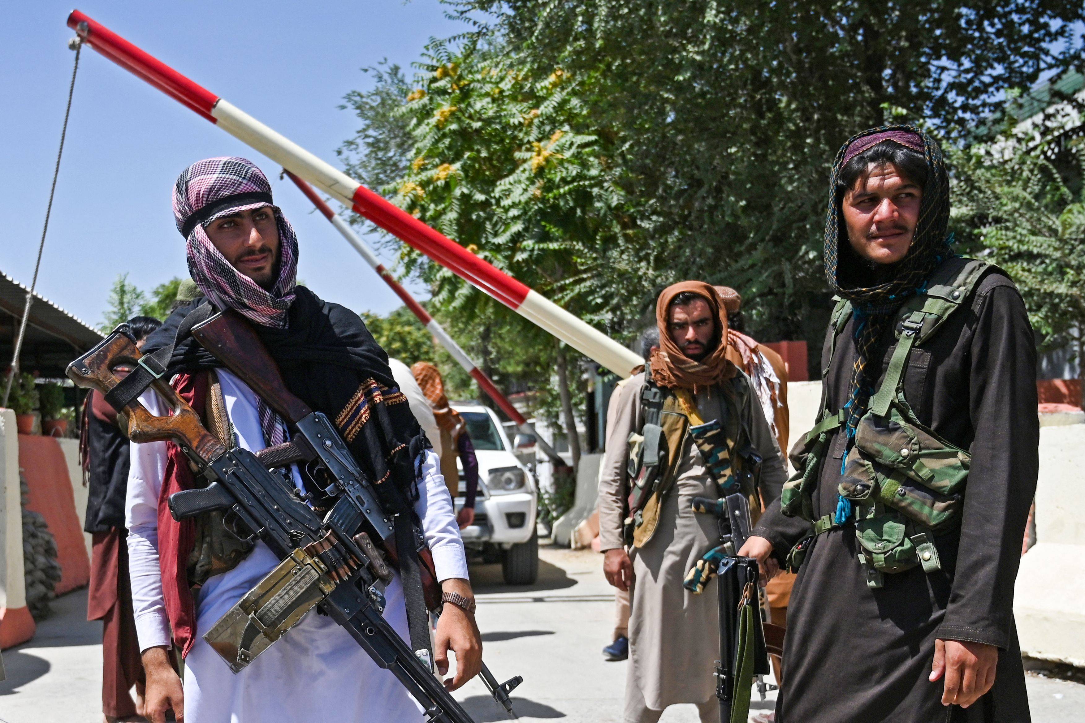 Taliban fighters stand guard along a roadside in Kabul on Monday. (Wakil Kohsar/AFP via Getty Images)