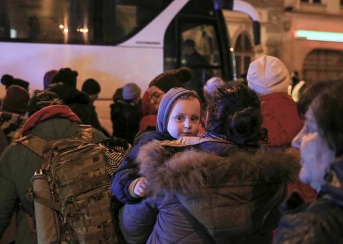 Women and children refugees fleeing the Russian invasion from Ukraine board a bus to Warsaw in Przemysl, Poland. (Visar Kryeziu/AP)