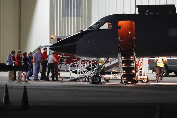 Medical personnel and visitors gather at the nose of a transport plane carrying Otto Warmbier in June 2017. (John Minchillo/AP)  