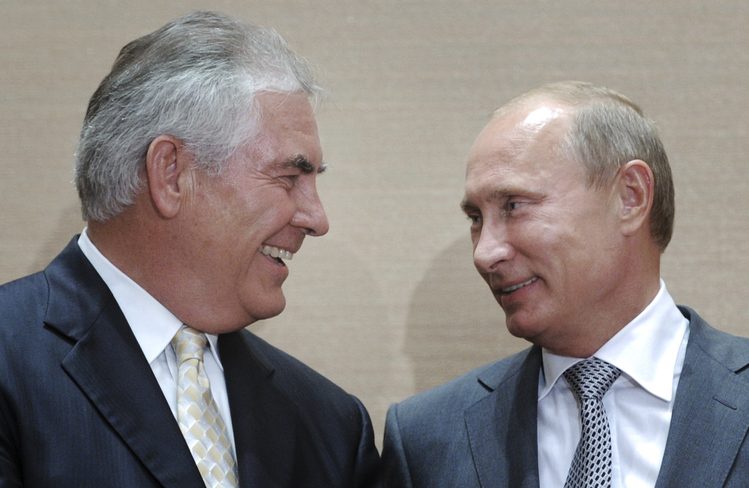 Russian Prime Minister Vladimir Putin cracks a very rare smile as he signs a huge oil exploration deal with Rex Tillerson. (Alexei Druzhinin/RIA Novosti via AP)</p>  