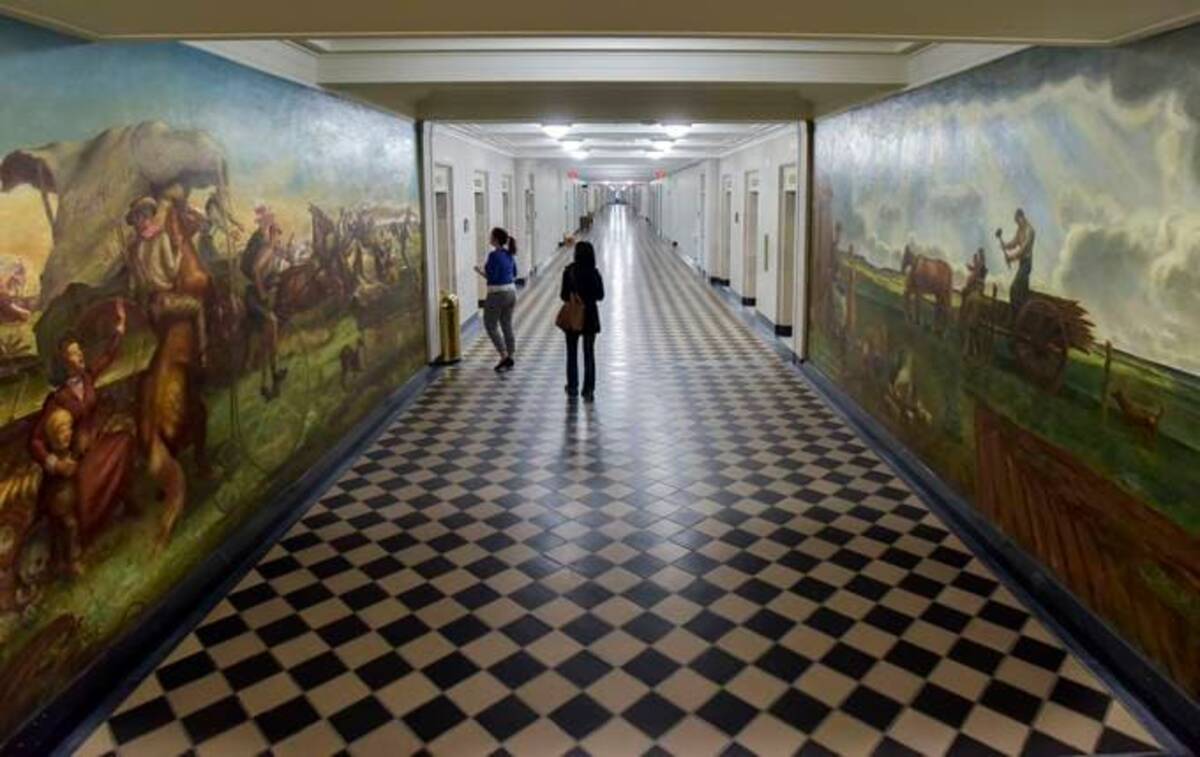 Just outside of the Bureau of Land Management offices, artist John Steuart Curry painted The Oklahoma Land Rush, left, and The Homestead and the Building of the Barbed Wire Fence murals in 1939. (Doug Kapustin for The Washington Post)