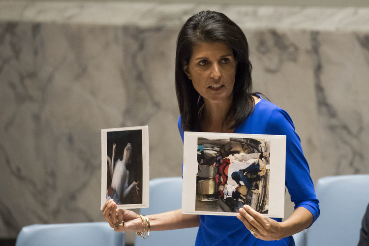 U.S. Ambassador to the United Nations Nikki Haley holds up photos of victims of the Syrian chemical attack during a meeting of the United Nations Security Council last Wednesday. (Drew Angerer/Getty Images)</p>  