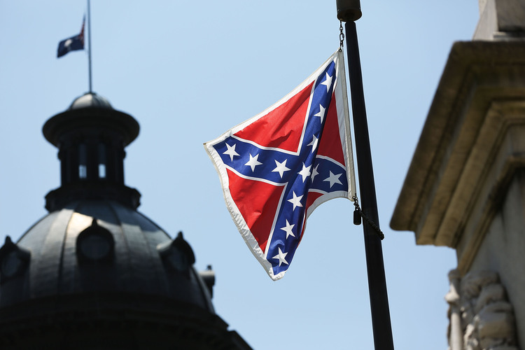 The Confederate flag is seen flying on South Carolina's Capitol grounds last June. Today it is gone.&nbsp;(Photo by Joe Raedle/Getty Images)</p>  