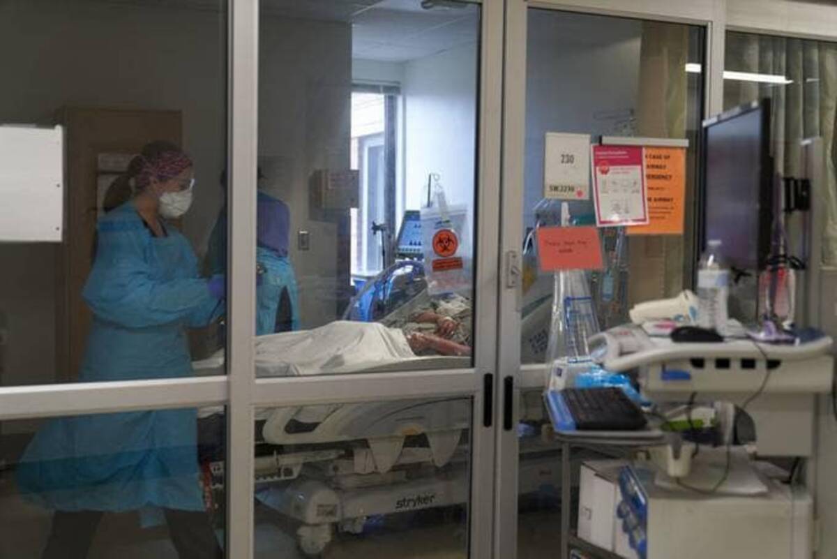 Health care workers treat a patient on the covid-19 intensive care unit floor of the University of Massachusetts (UMass) Memorial Hospital in Worcester, Mass., on Monday. (Allison Dinner/Bloomberg News)