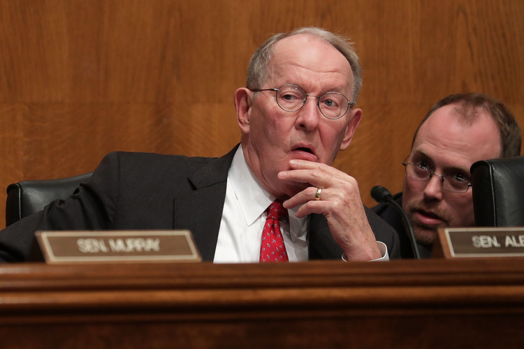 Lamar! confers with an aide as DeVos testifies. (Chip Somodevilla/Getty Images)</p>
