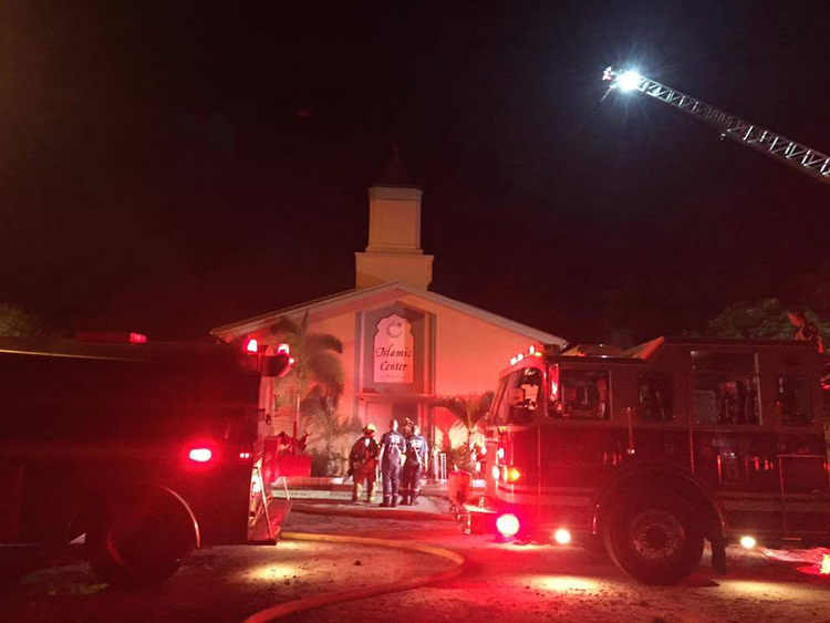 Firefighters work at the scene of a suspected arson at the Islamic Center of Fort Pierce, Florida, this morning.&nbsp;(St. Lucie Sheriff's Office via AP)</p>  