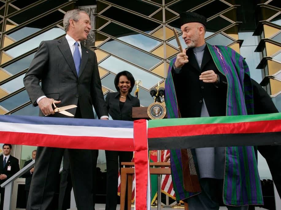 President George W. Bush and Afghan President Hamid Karzai get ready to cut a ribbon to officially open the U.S. Embassy in Kabul in 2006. (Charles Dharapak/AP)