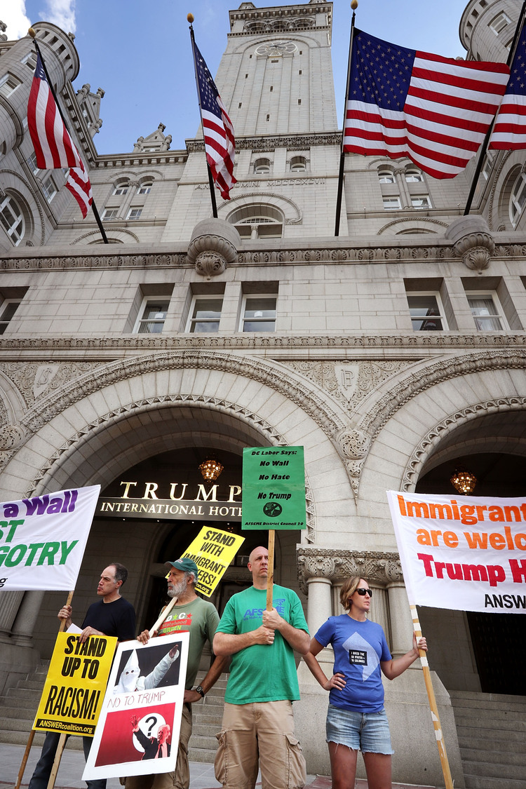 Demonstrators gather in front of the newly opened Trump International Hotel.&nbsp;(Chip Somodevilla/Getty)</p>  
