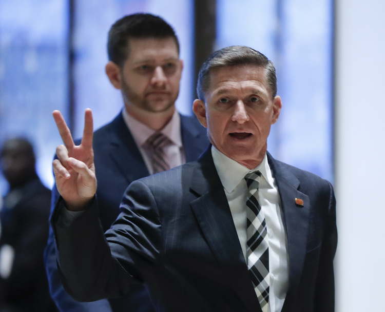 Michael Flynn gestures as he arrives with his son, Michael Jr., at Trump Tower during the transition. (Carolyn Kaster/AP)</p>