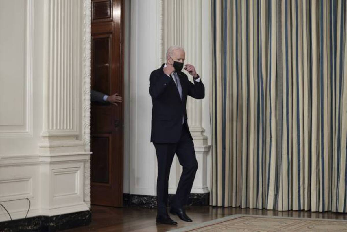 Biden takes off his face mask as he arrives to deliver remarks on his administration's COVID-19 response and vaccination program. (Anna Moneymaker/Getty Images)