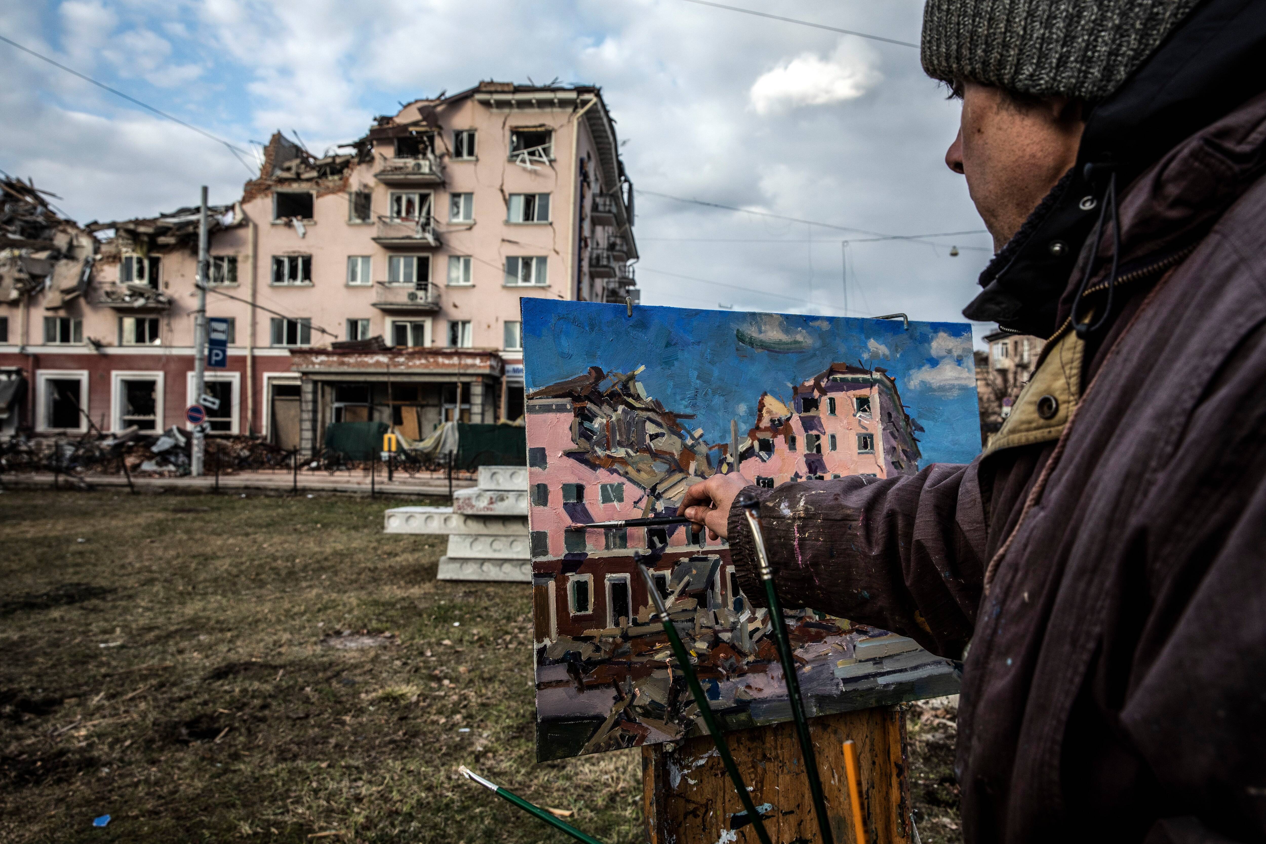 Painter Victor Onishchenko, 43, paints the damaged Hotel Ukraine that was hit by a Russian airstrike in the city of Chernihiv, Ukraine on April 4. (Heidi Levine for The Washington Post).