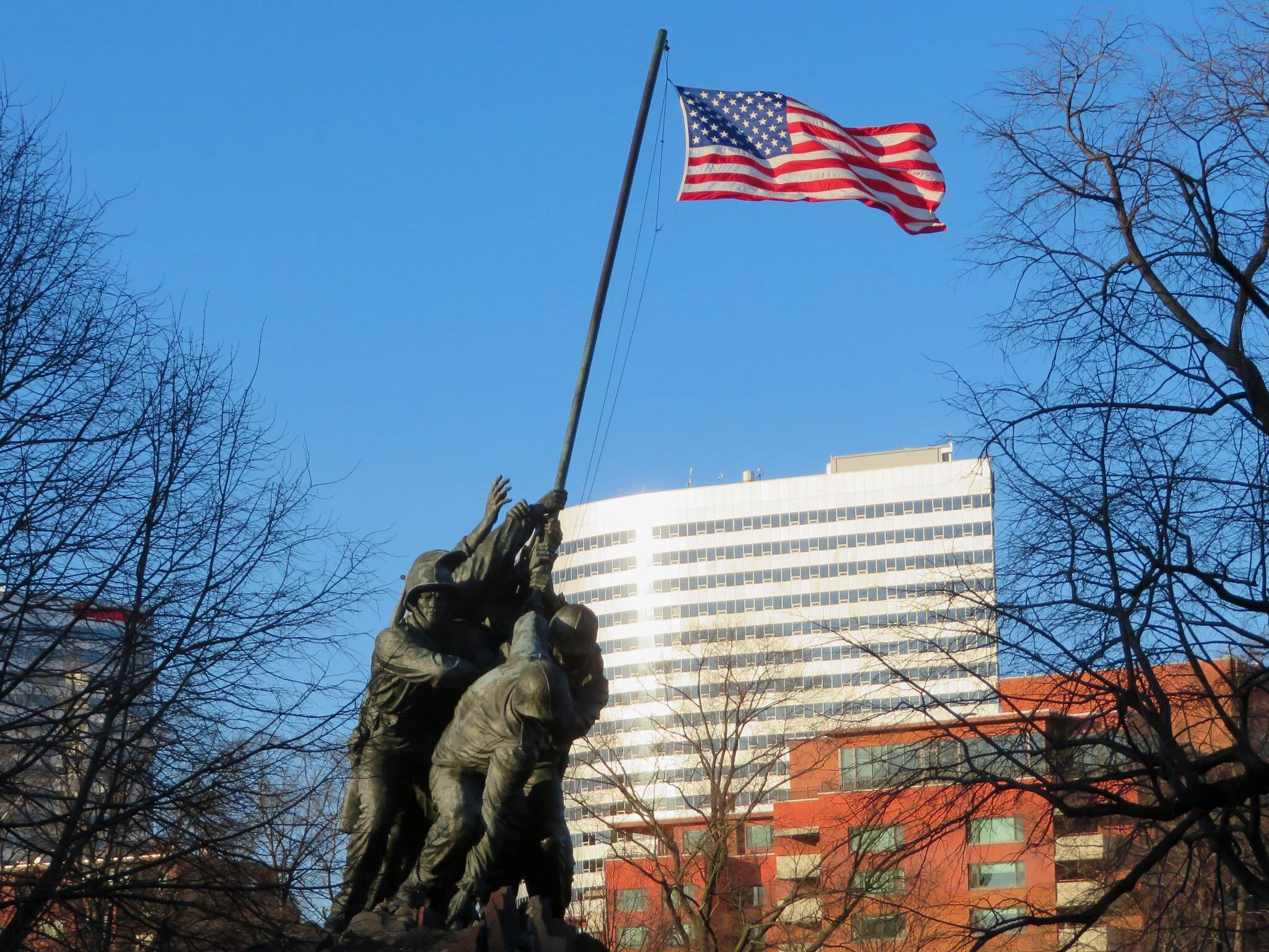 Bright sun and strong wind at the Iwo Jima Memorial in Arlington, Virginia, with a Rosslyn office building in the distance on March 5.