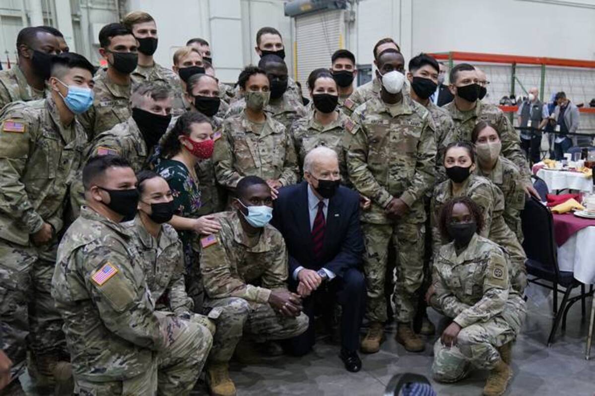 President Biden poses for a photo with soldiers during a visit to Fort Bragg army base to mark the coming Thanksgiving holiday on Monday in N.C. (Evan Vucci/AP)