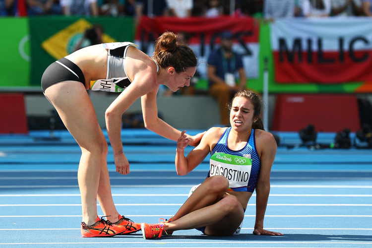 Abbey D'Agostino is helped up by Nikki Hamblin of New Zealand after a collision during the Women's 5000m race. (Ian Walton/Getty)</p>