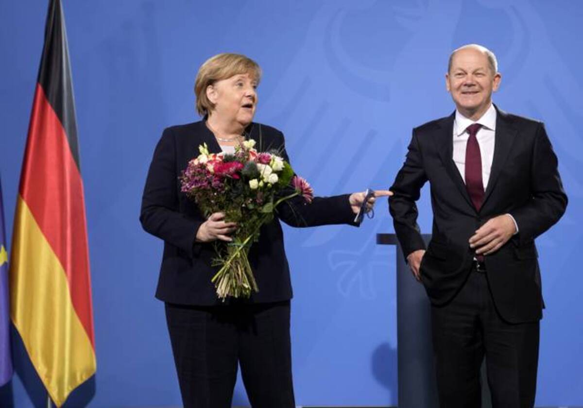 Newly elected German Chancellor Olaf Scholz, right, gave flowers to former Chancellor Angela Merkel during a handover ceremony in the chancellery in Berlin, Wednesday, Dec. 8, 2021. (Photo/Markus Schreiber)