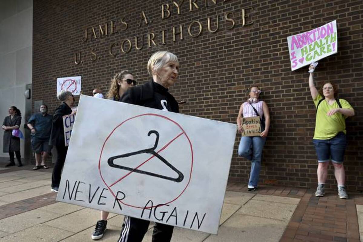 Carol Mickey, 80, carries her sign during a protest outside federal court in Philadelphia on Tuesday. (Tom Gralish/The Philadelphia Inquirer via AP)