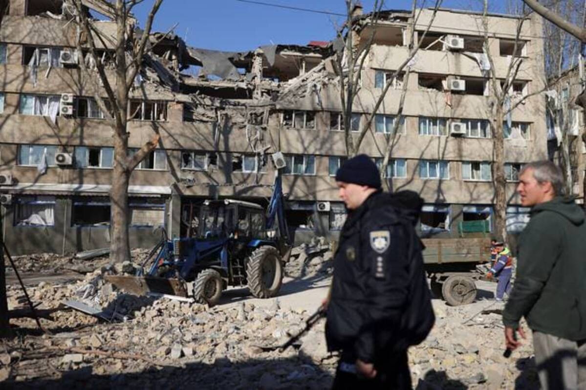 People clean the pavement in front of a damaged building after a military strike in Mykolaiv, Ukraine on Monday. (REUTERS/Nacho Doce)