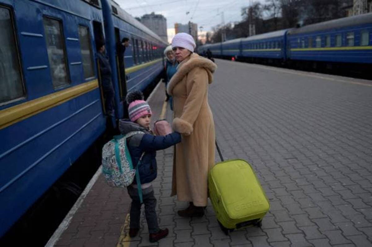 A woman and a girl hold hands next to an evacuation train on the platform in Odessa, Ukraine. (Bulent Kilic/AFP/Getty Images)