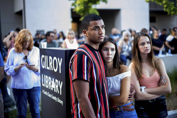 Derrick Smith, left, embraces Sara Sakamoto on Monday during a vigil for victims of Sunday's deadly shooting at the Gilroy Garlic Festival. (Noah Berger/AP)  