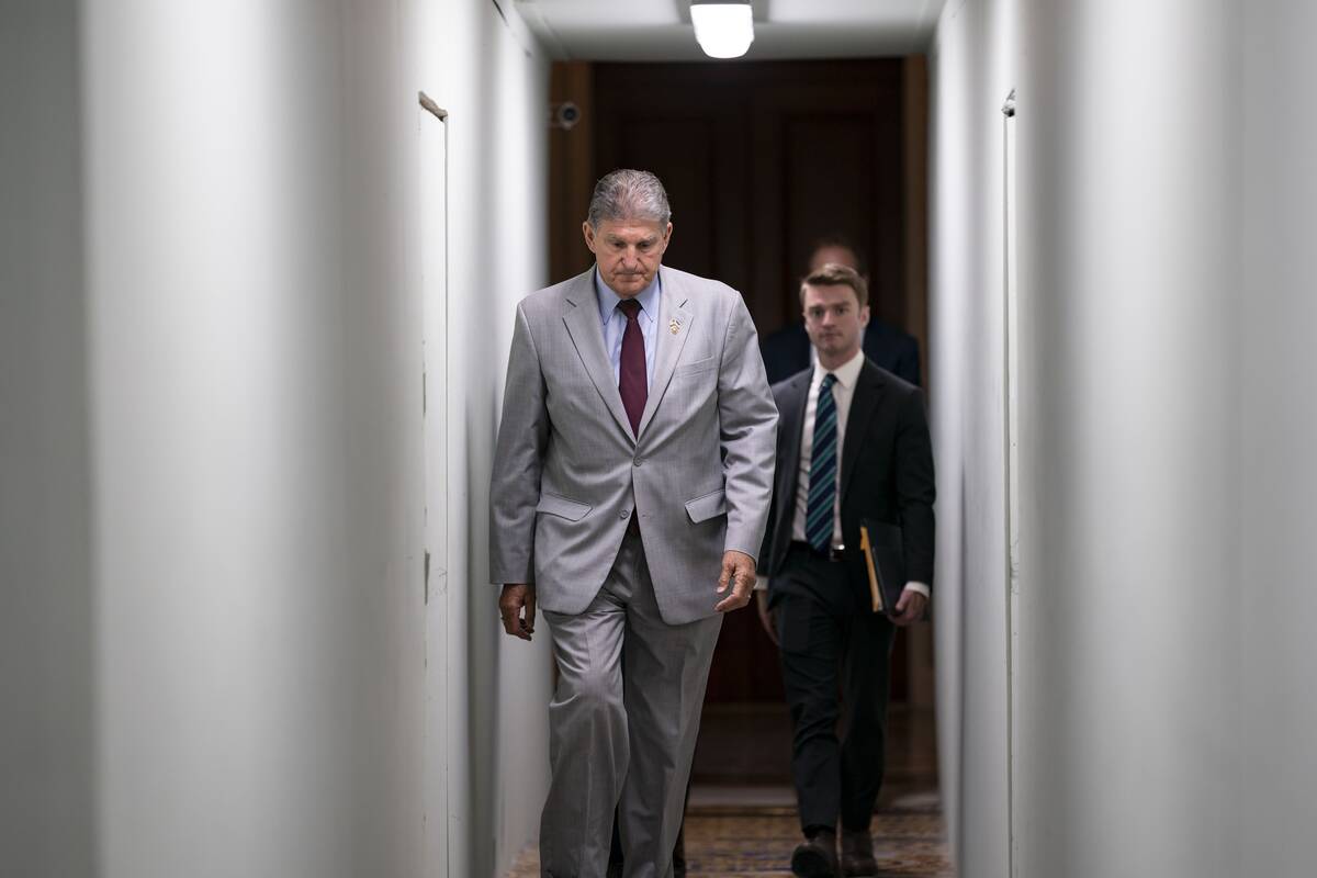 Sen. Joe Manchin III (D-W.Va.) heads to a meeting with fellow Democrats at the Capitol in June via a construction tunnel. (J. Scott Applewhite/AP)