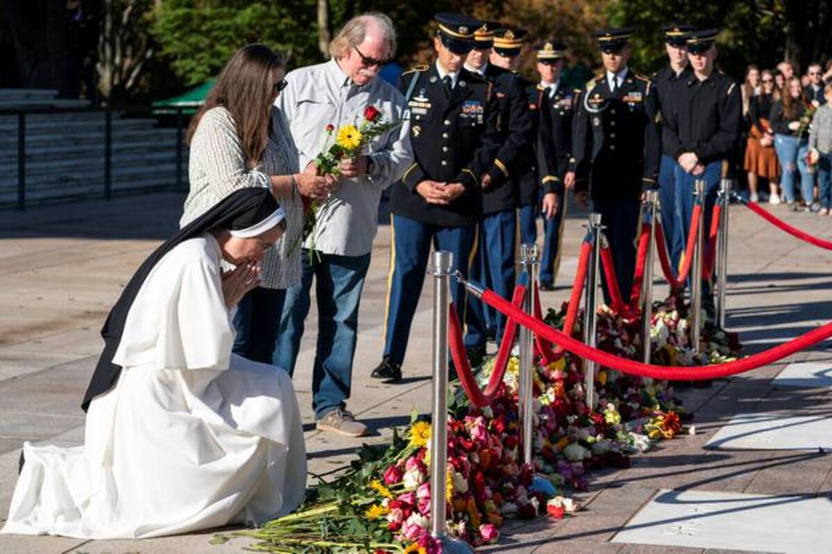 A nun prays after placing flowers during a centennial commemoration event at the Tomb of the Unknowns Tuesday in Arlington National Cemetery. (Alex Brandon/Pool via Reuters)
