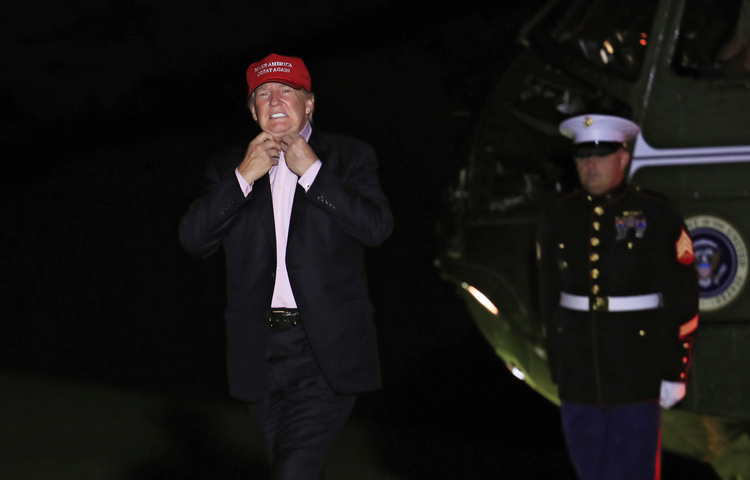 Donald Trump walks across the South Lawn last night after arriving back at the White House on Marine One from a weekend at his golf club in New Jersey. (Manuel Balce Ceneta/AP)  