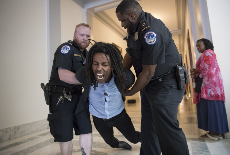 A demonstrator is taken into custody by Capitol Police outside the office of Ted Cruz. (J. Scott Applewhite/AP)  