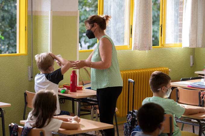 A teacher checks the temperature of a primary school student on the first day of the school year in Murcia, Spain. (Marcial Guillen/EPA)