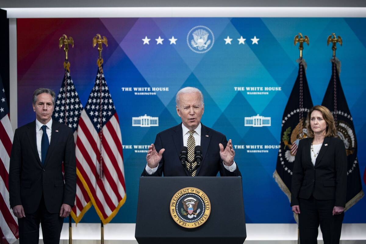 President Biden speaks as Deputy Secretary of Defense Kathleen Hicks, right, and Secretary of State Antony Blinken, left, listen on Wednesday, March 16. (Al Drago/Bloomberg)