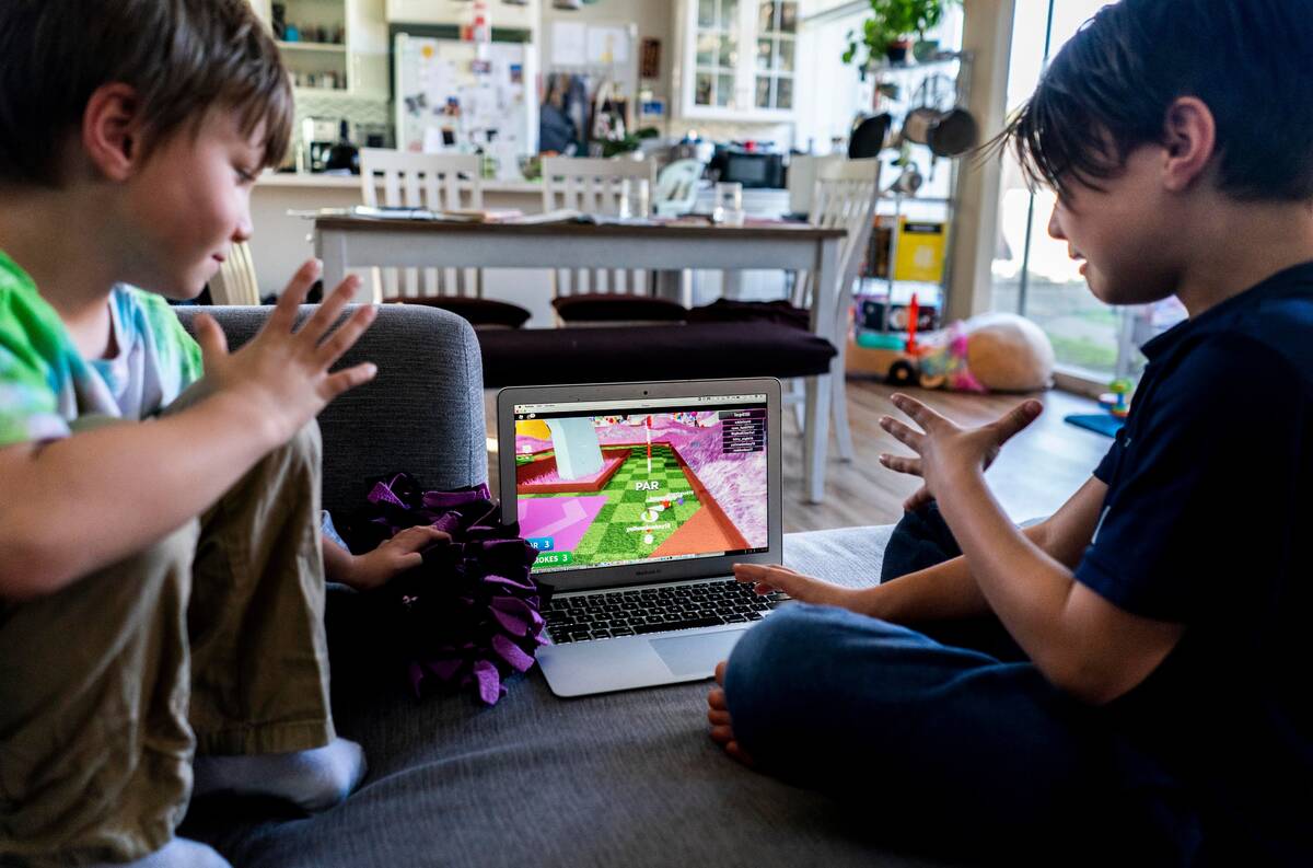 Eliott Lin, 6, and Isaiah Lin, 9, play a Roblox game at their home in California. (Melina Mara/The Washington Post)