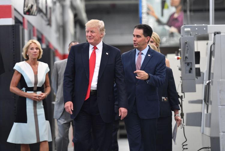 Donald Trump and Scott Walker arrive for a workforce development roundtable in Milwaukee on June 13. (Nicholas KammAFP/Getty Images)</p>  