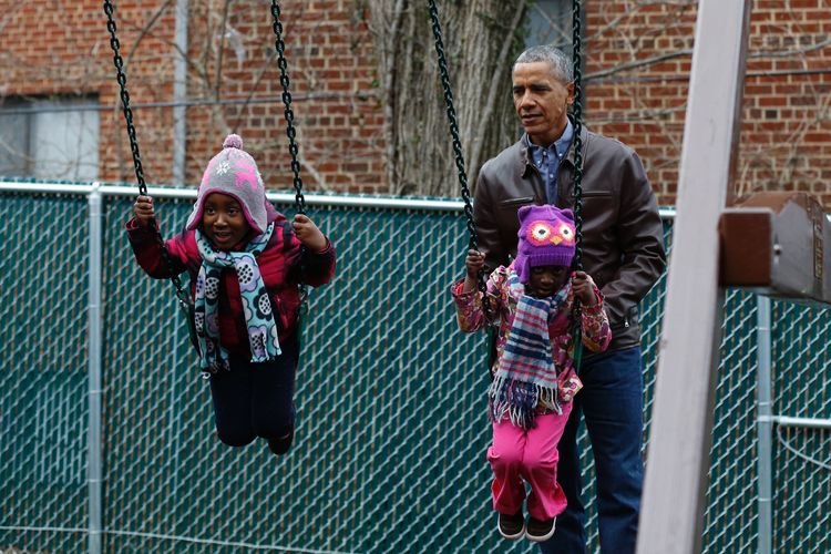 President Obama plays yesterday with children on a swing set donated by the first family at a homeless shelter in Washington. (Yuri Gripas/AFP/Getty Images)</p>  